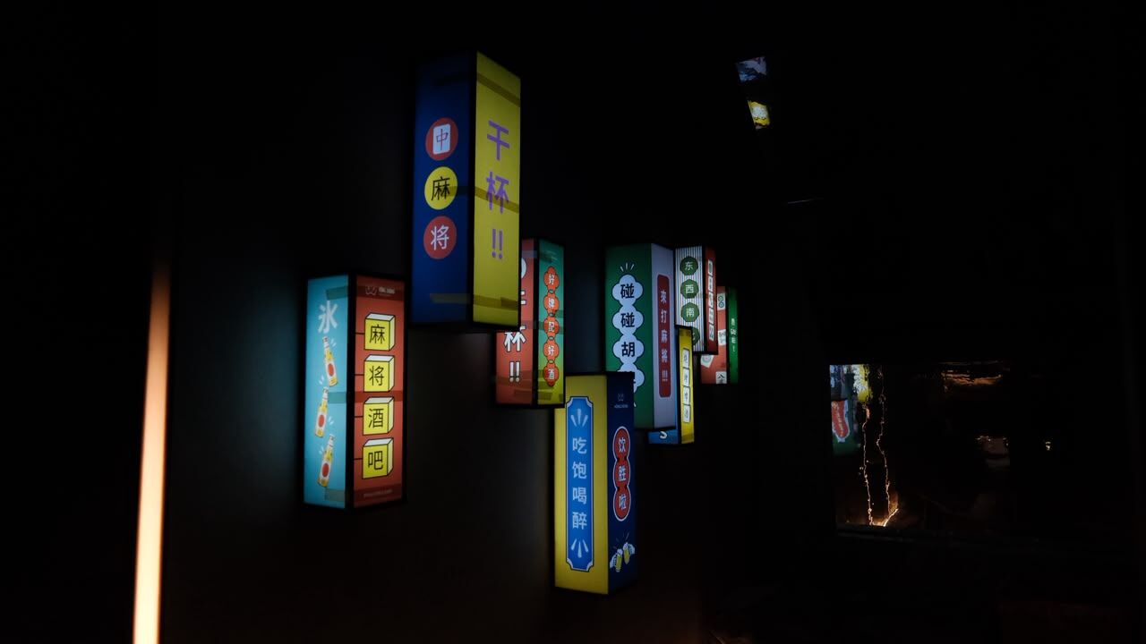 Deretan papan lampu warna-warni bertulisan aksara Tionghoa di dinding Hong Zhong Mahjong