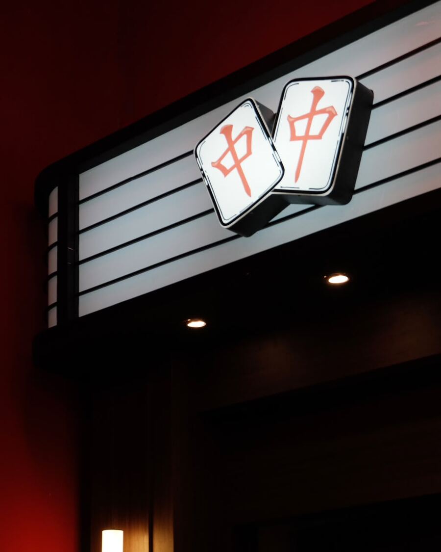 Papan bercahaya bergambar ubin mahjong 中 di dinding merah Hong Zhong Mahjong