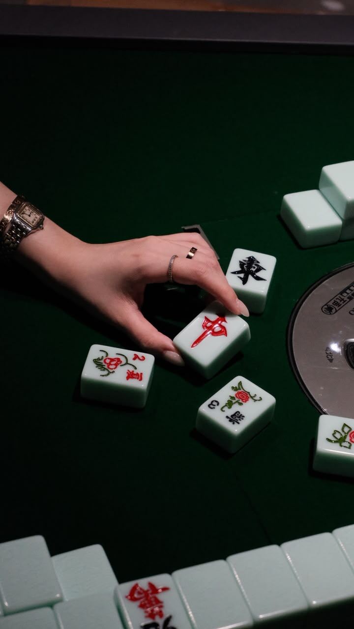 Ubin mahjong di atas meja berlapis kain hijau